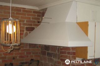 Valkoinen huuva suoralla tiiliseinällä